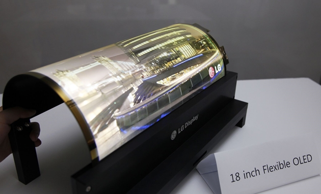LG디스플레이 직원이 곡률반경 30R을 자랑하는 18인치 플렉시블 OLED를 말아서 시연해 보이고 있다.